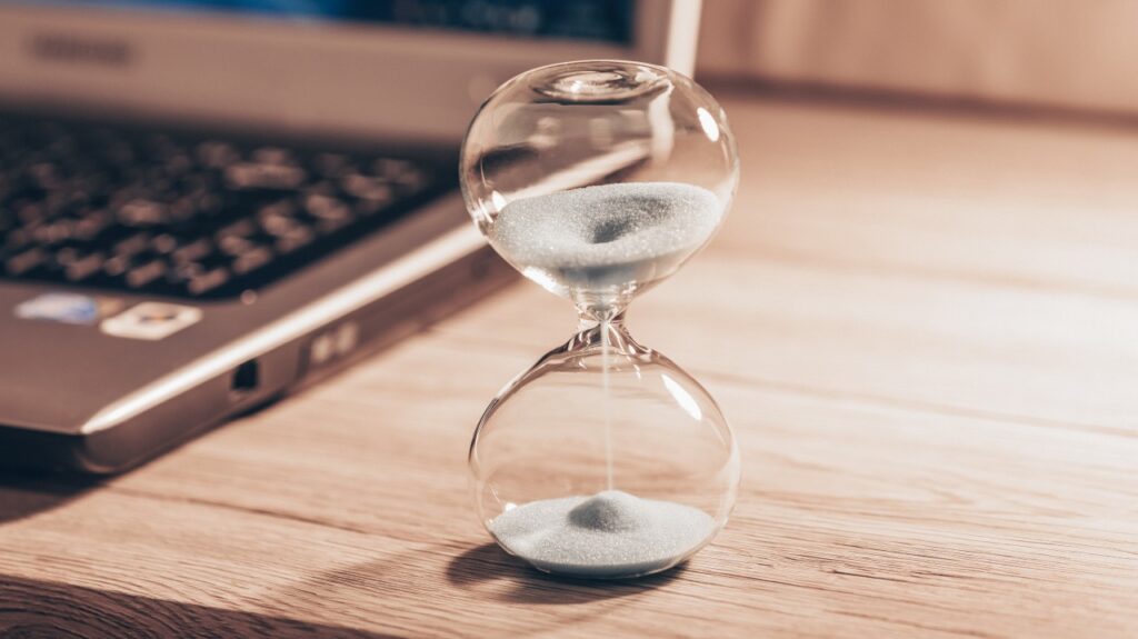 Hourglass next to laptop