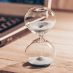 Hourglass next to laptop